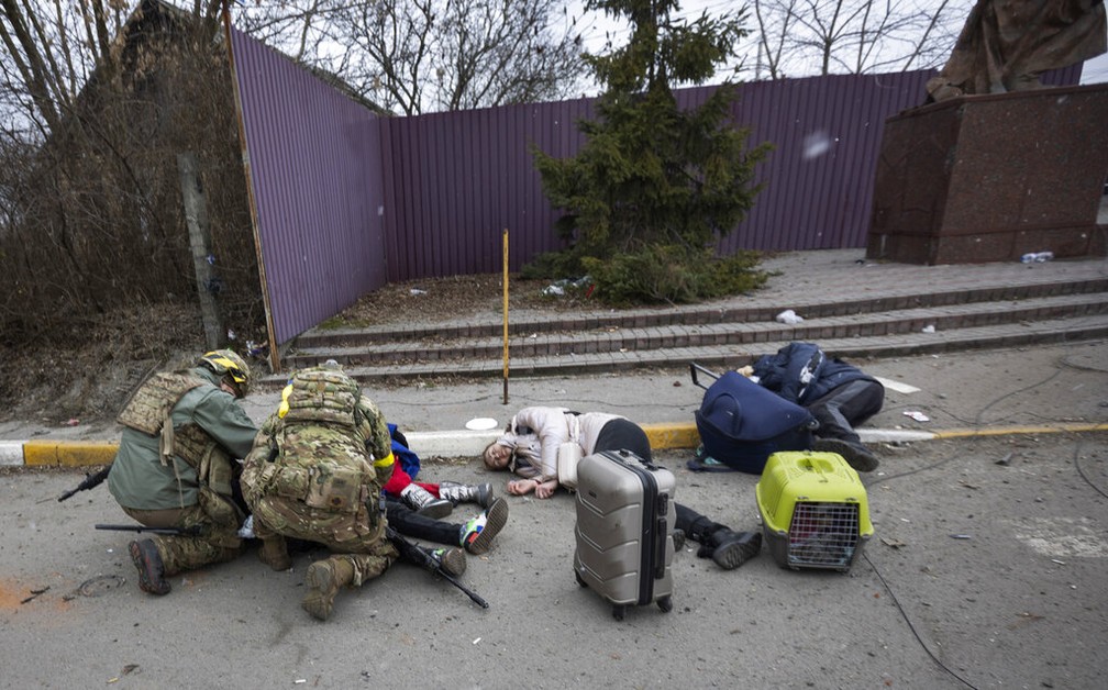 Soldados ucranianos tentaram socorrer pessoas atingidas por ataque de morteiro no domingo (6) — Foto: Andriy Dubchak/AP