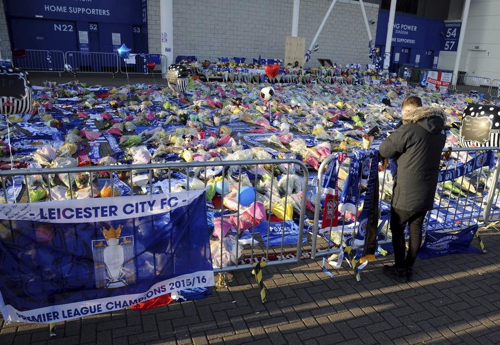Uma pessoa presta homenagem Ã s vÃ­timas do acidente de helicÃ³ptero, que matou o presidente do Leicester City. â€” Foto: Rui Vieira/Associated Press