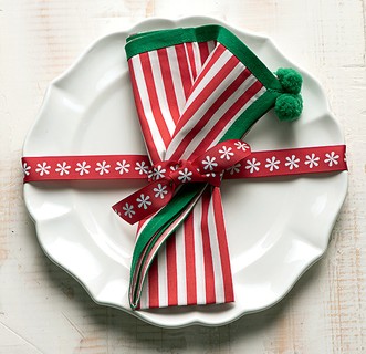“Embale” cada prato na mesa de Natal. A fita que envolve a louça também prende o guardanapo