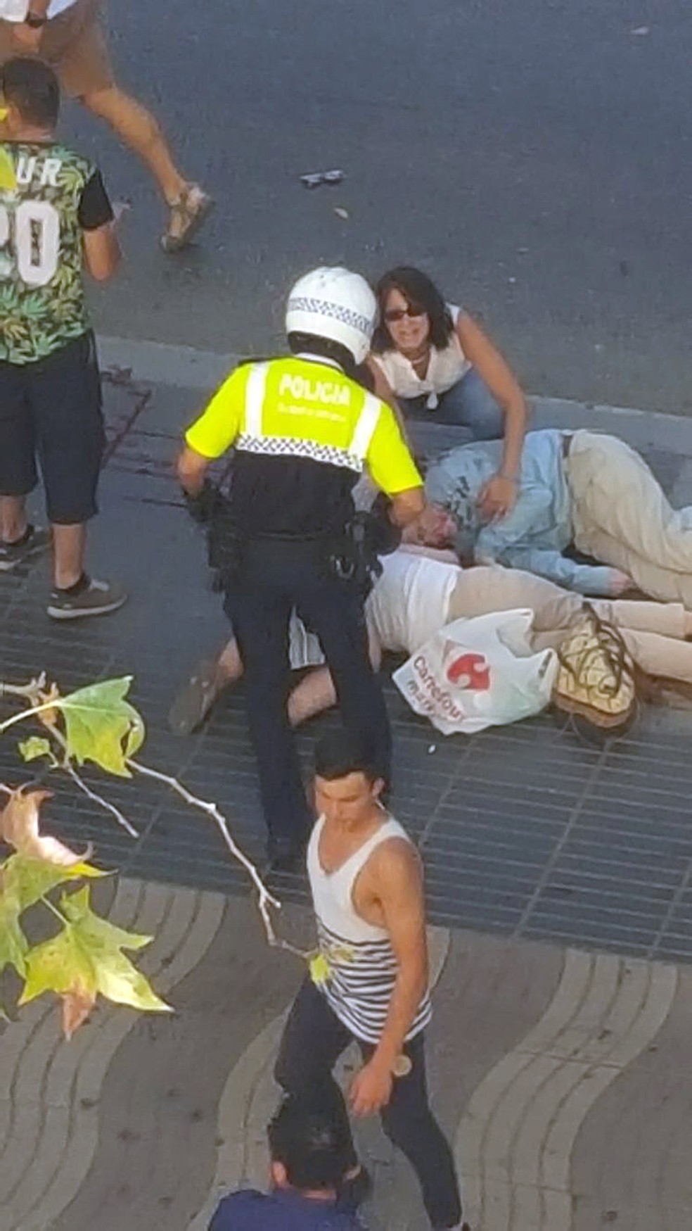 Policial socorre vítimas de atropelamento em ataque terrorista em Barcelona, na Espanha  (Foto: Giselle Loots/ REUTERS)