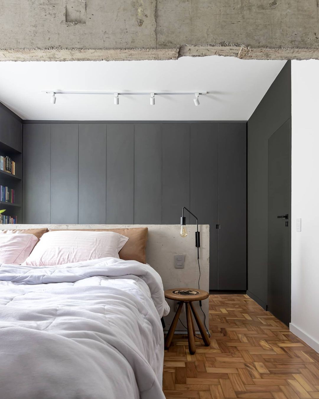 Décor do dia: quarto com cabeceira de concreto e armário preto (Foto: Monica Assan)