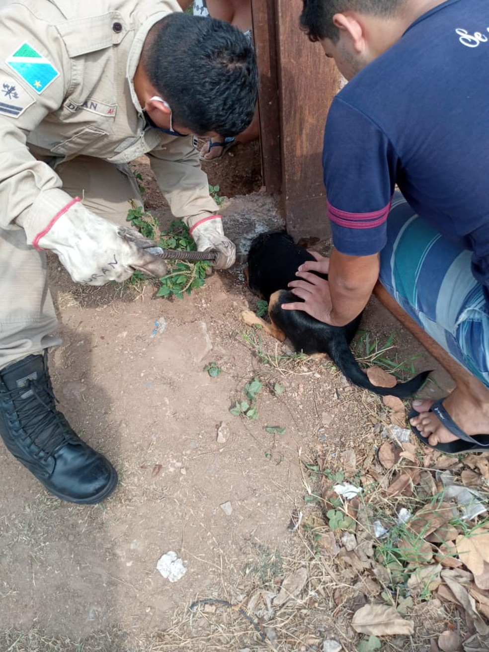 Bombeiro e dono no resgate do cachorro preso em buraco, em bairro de Corumbá. — Foto: Corpo de Bombeiros/Divulgação