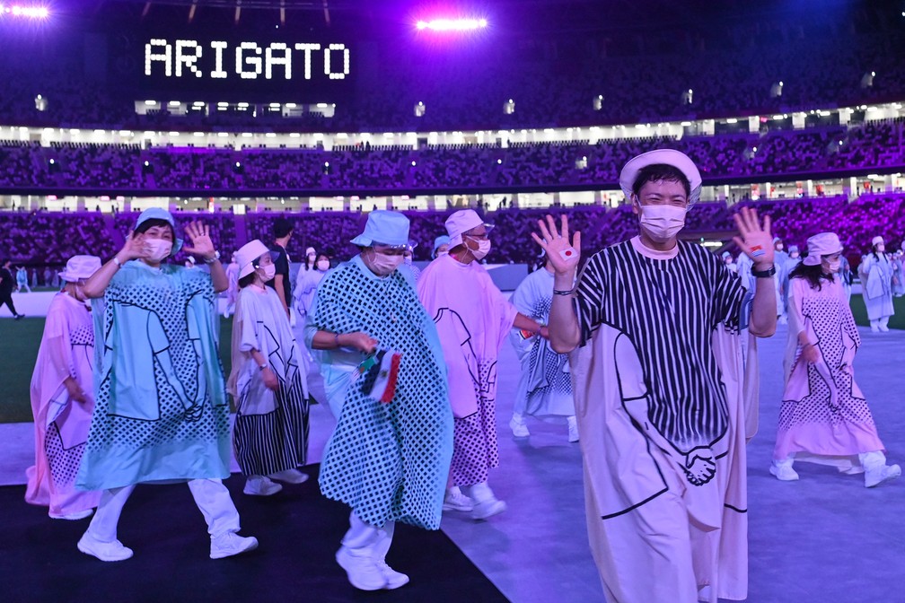 Os artistas acenam para a multidão na cerimônia de encerramento dos Jogos Olímpicos de Tóquio, no Estádio Olímpico — Foto: Adek BERRY / AFP