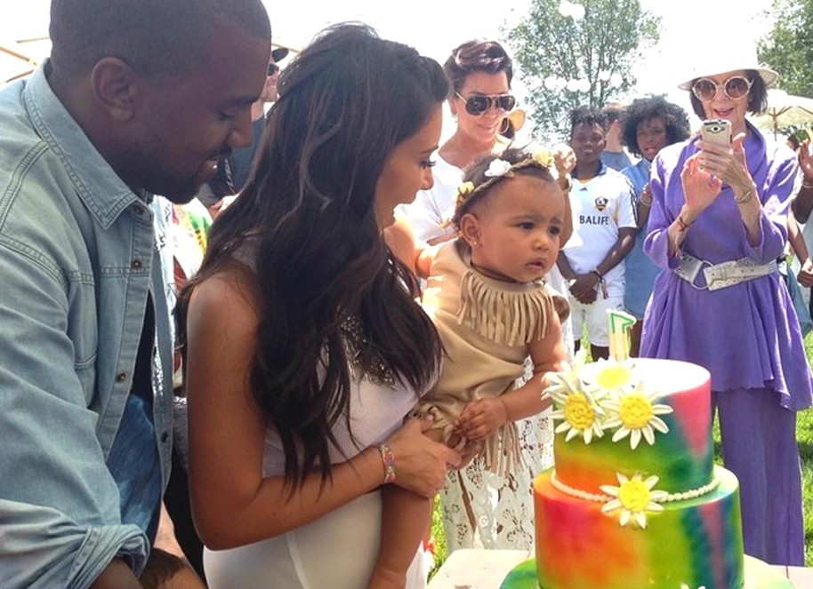 Kim Kardashian com North nos braços, ao lado do marido, Kanye West, e da mãe, Kris Jenner (de roupa branca e óculos escuros, ao fundo). (Foto: Instagram)