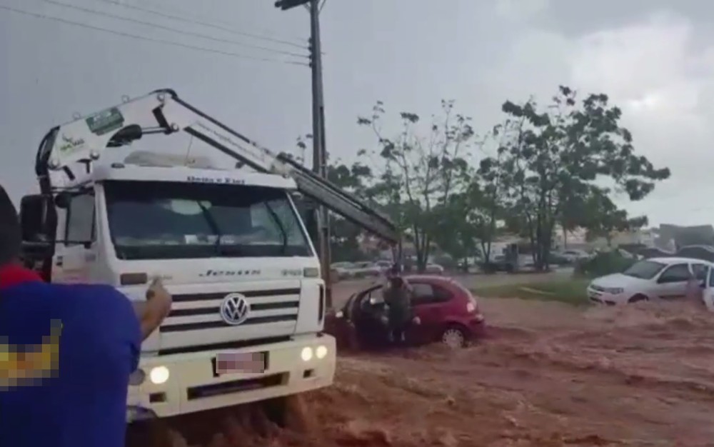 Imagem mostra o momento em que ocupantes de carro são içados por guincho (Foto: TV Anhanguera/Reprodução)
