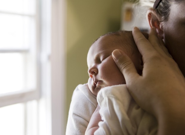 Mãe segura recém-nascido no colo (Foto: Thinkstock)