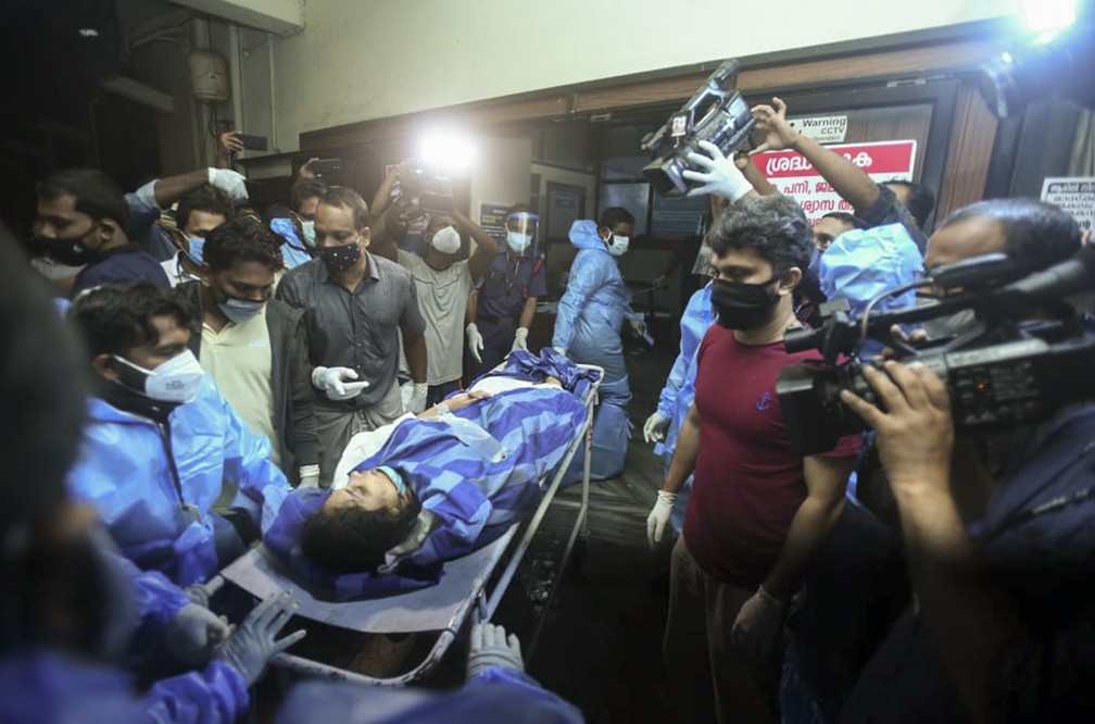 Uma das pessoas feridas após voo da Air India Express derrapar durante pouso no aeroporto de Calicute é levada para tratamento no Medical College Hospital em Calicute, Kerala, Índia — Foto: AP Photo