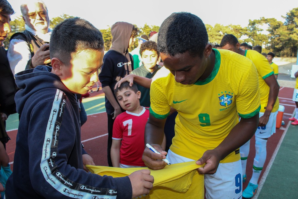 Endrick, atacante do Palmeiras e da seleção brasileira sub-17, assina camisa no fim do jogo do Brasil  (Foto: Julien Zajac)