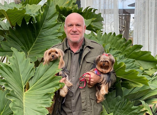 O paisagista Gilberto Elkis posa entre folhagens com seus dois cachorros (Foto: Instagram / Reprodução)