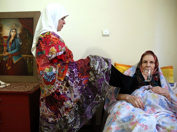 Ela também cuida de idosos (Foto: Ebrahim Noroozi/AP)