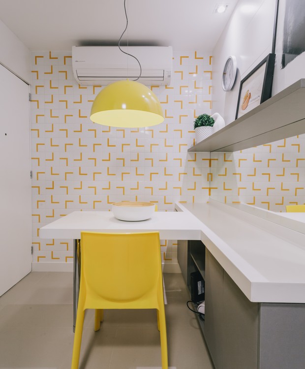 A cozinha é outro ambiente que recebe cor: o amarelo passa pelos azulejos, pela cadeira e pelo pendente (Foto: Giraldi Ineves/ Divulgação)