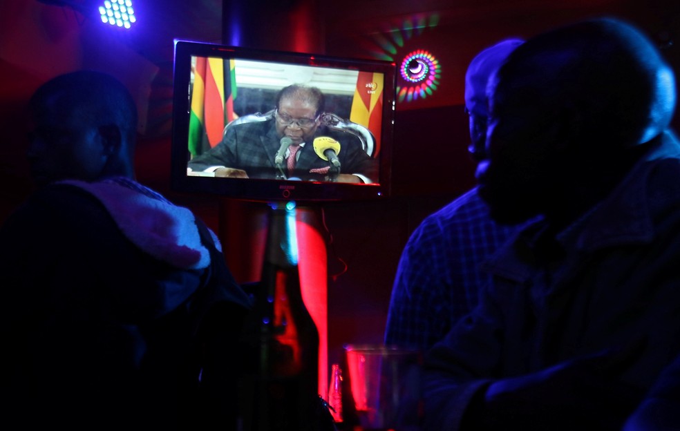 As pessoas assistem discurso do presidente do Zimbábue, Robert Mugabe, em um bar em Harare (Foto: Philimon Bulawayo/Reuters)