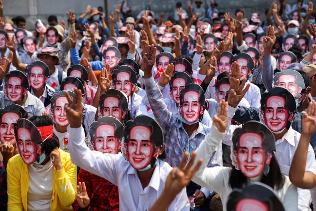Manifestantes usando máscaras com o rosto de Aung San Suu Kyi protestam na cidade de Yangon, em Mianmar, neste domingo (28) — Foto: Stringer/Reuters