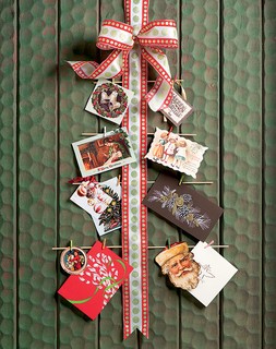 Ideia simples e cheia de bossa: uma fita com laço na ponta serve de apoio para fotografias da família ou cartões de Natal com bons desejos