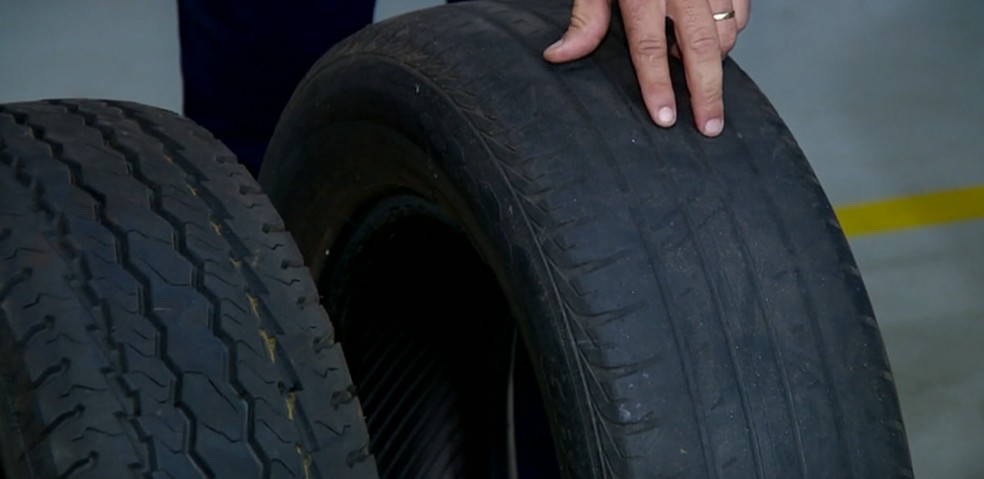 Mecânico mostra pneu com sulcos e outro sem, já com desgaste — Foto: Reprodução/EPTV