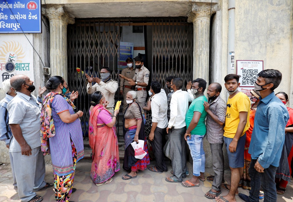 Policiais informam população sobre a falta de vacina contra a Covid-19 no portão de um centro de imunização em Ahmedabad, na Índia, em 29 de junho de 2021 — Foto: Amit Dave/Reuters