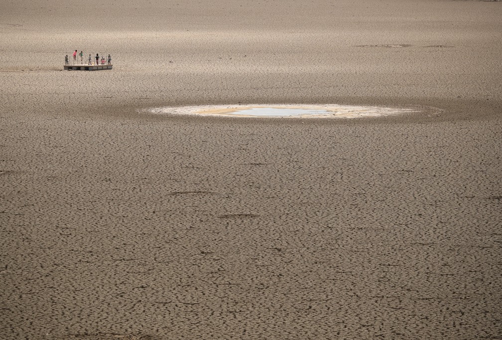 17 de novembro - Crianças brincam ao redor de um terreno de argila endurecida na barragem seca da cidade de Graaff-Reinet, na África do Sul — Foto: Mike Hutchings/Reuters
