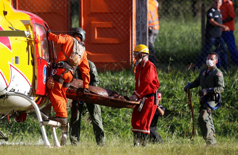 Equipe de resgate carrega corpo retirado da lama dois dias depois do rompimento da barragem da Vale, em Brumadinho. â€” Foto: Adriano Machado/Reuters