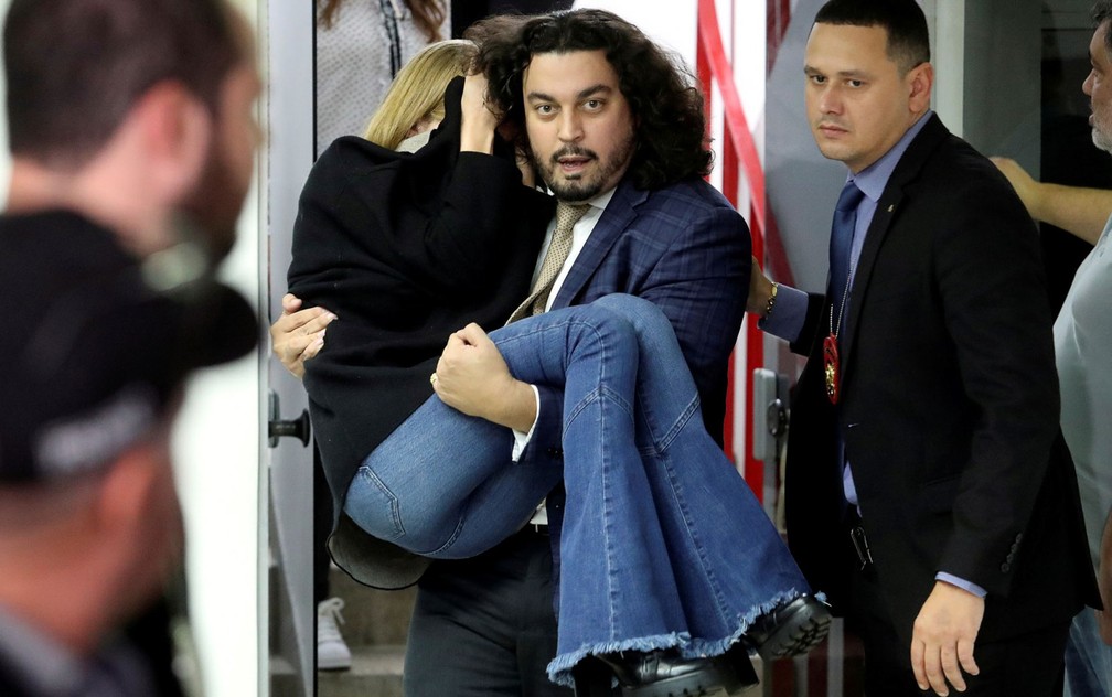 7 de junho - Najila Trindade sai carregada por seu advogado de delegacia em SP após passar mal e desmaiar durante depoimento no caso em que acusou o jogador Neymar Jr. de agressão e estupro — Foto: Amanda Perobelli/Reuters