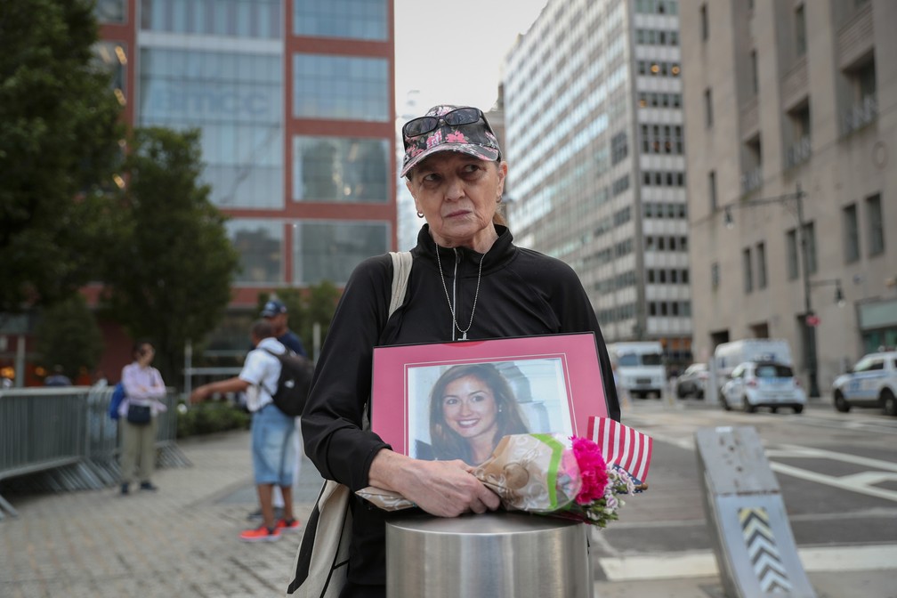Connie Dray segura uma foto e flores em homenagem à sua sobrinha e vítima do ataque terrorista de 11 de setembro de 2001 em Nova York, nos EUA — Foto: Shannon Stapleton/Reuters