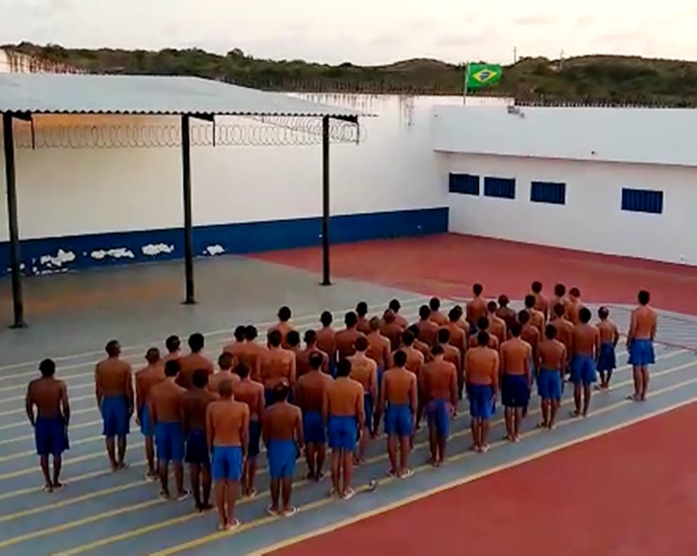Reunidos no pÃ¡tio, presos de AlcaÃ§uz cantam o hino nacional  â€” Foto: Sejuc/DivulgaÃ§Ã£o