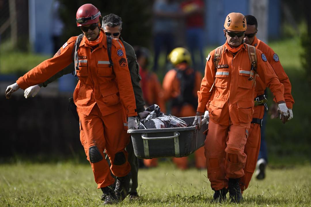 Bombeiros carregam corpo resgatado em Brumadinho