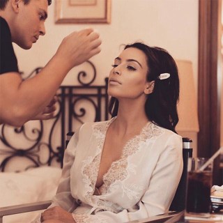 No quinto aniversário de casamento do casal, Kim Kardashian West compartilhou novas fotos dentro do dia do casamento, incluindo esta de sua maquiagem sendo feita antes do casamento