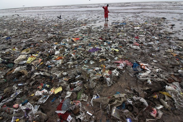A man stands on a plastic waste at a beach in Mumbai, India on 30 June 2019. The trash was pushed onto Juhu beach by a recent storm. (Photo by Himanshu Bhatt/NurPhoto via Getty Images) (Foto: NurPhoto via Getty Images)