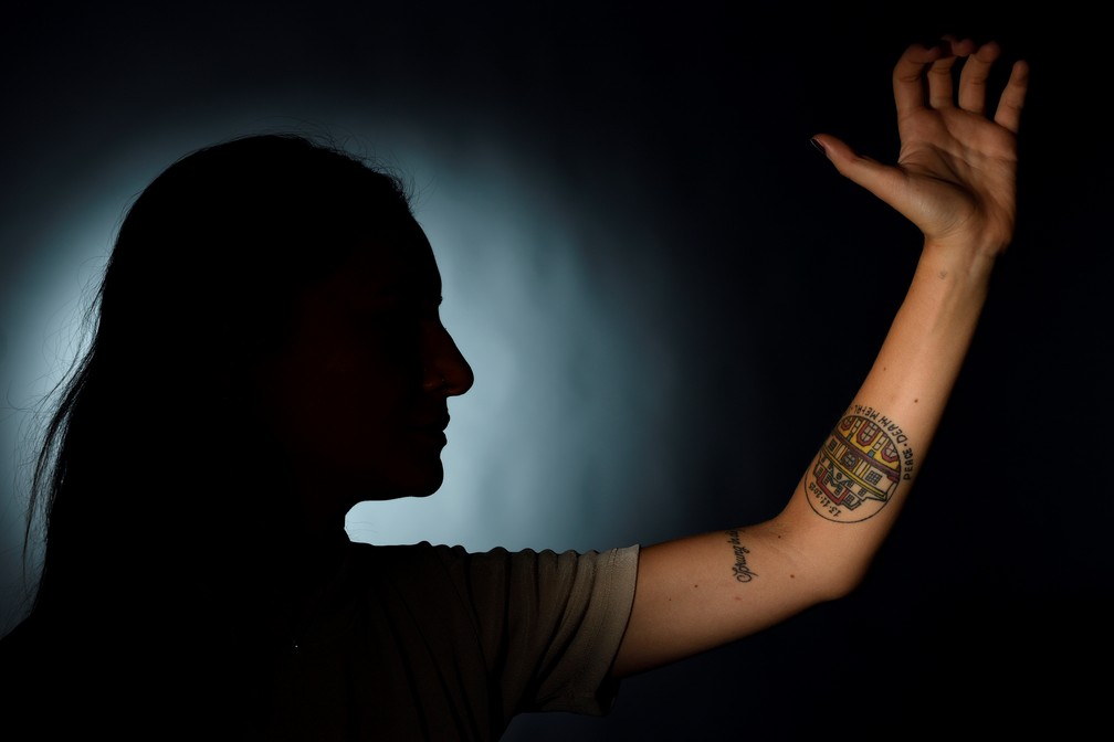 Nahomy Beuchet carrega em seu braço tatuagem do Bataclan com a data do ataque e as palavras 'Paz, Amor e Metal' (Foto: ERIC FEFERBERG / AFP)