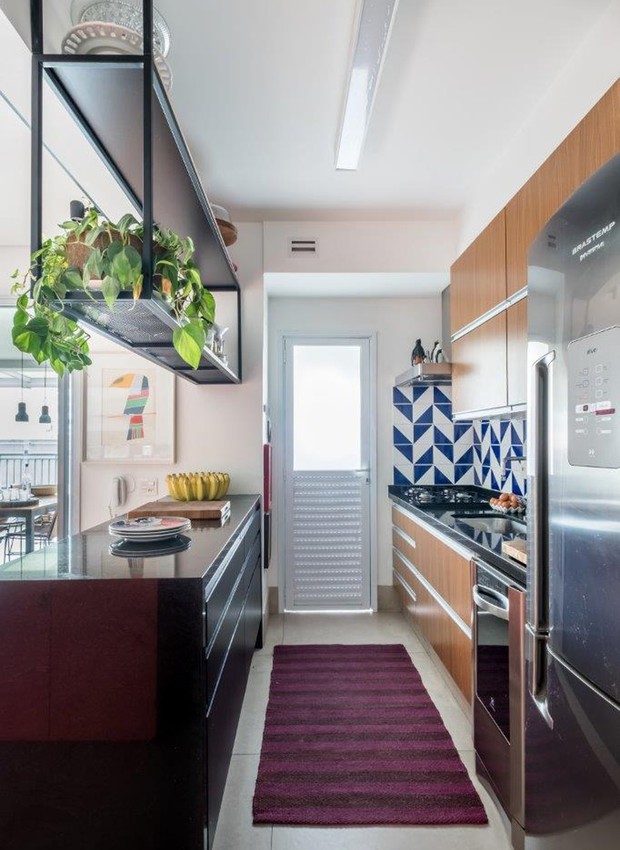 COZINHA | Junto à bancada, a prateleira suspensa de serralheria divide o espaço entre sala e cozinha (Foto: Nathalie Artaxo/ Divulgação)