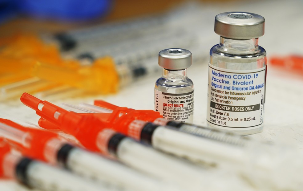 Vacinas bivalentes da Pfizer (esquerda) e Moderna (direita) — Foto: Steve Helber/AP