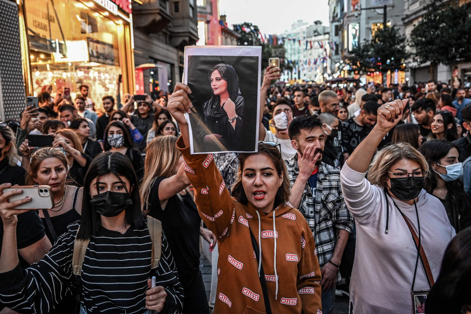 Manifestante marcha pela avenida Istiklal, em Istambul, enquanto segura um retrato de Mahsa Amini durante ato em apoio à jovem iraniana que morreu após ser presa em Teerã  — Foto: Ozan KOSE / AFP