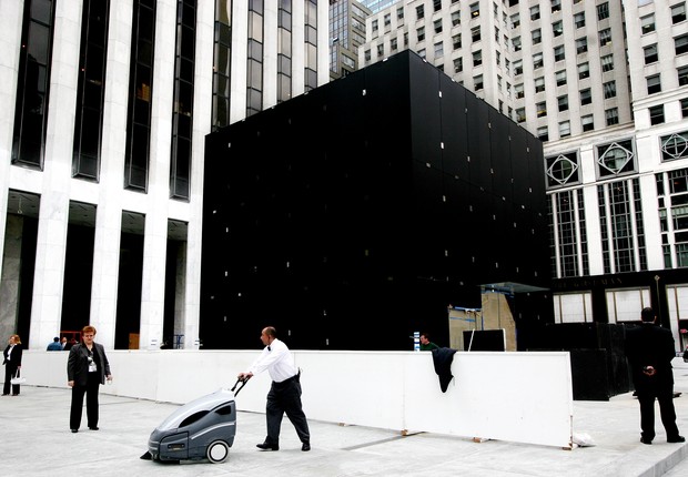 Inauguração da Apple Store da Quinta Avenida, em  Nova York, em maio de 2006:  oculto sob a lona estava o cintilante cubo de vidro de dez metros de altura que guarnece a entrada subterrânea da loja. O projeto arquitetônico remete à pirâmide do Louvre, do  (Foto: Mark Lennihan)