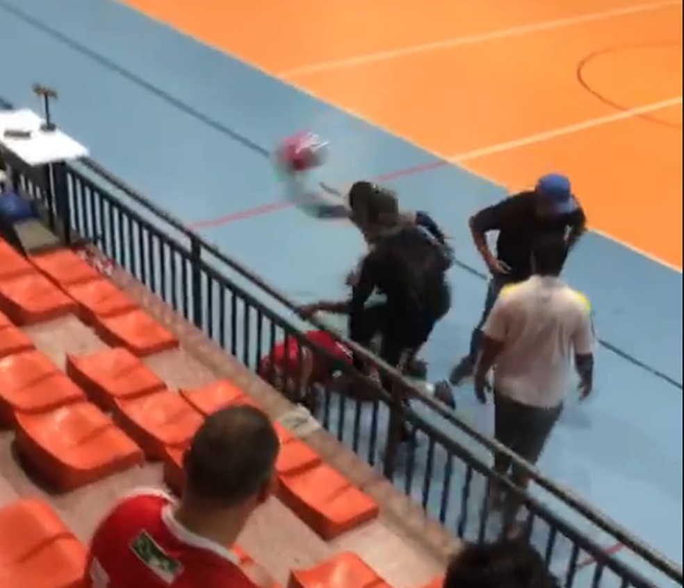 Imagem mostra torcedor no chão sendo agredido com capacete no Palácio dos Esportes, na noite desta terça-feira (19) — Foto: Reprodução/Inter TV Cabugi