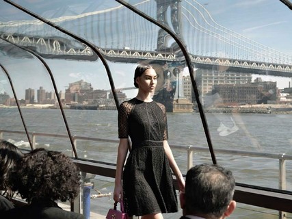 Modelo desfila em barco diante da Brooklyn Bridge