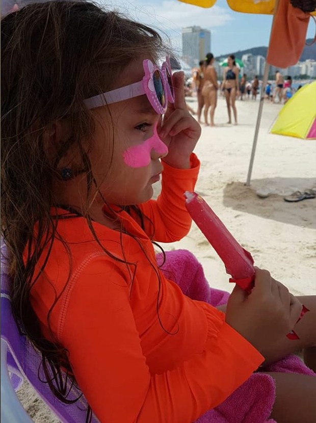 Sophia, filha de Flávia Monteiro, se refresca com picolé em praia do Rio (Foto: Reprodução/Instagram)