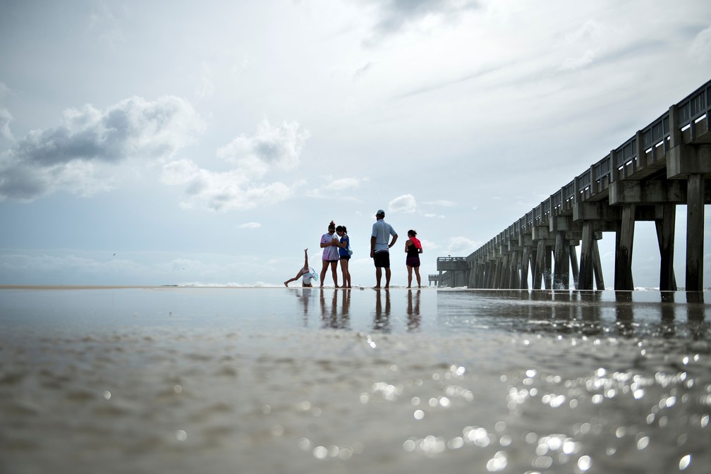 Pessoas caminham em Panama City Beach, na Flórida, na terça-feira (9), antes da chegada do furacão Michel  — Foto: Brendan Smialowski / AFP 