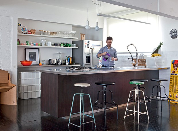 Azulejos vintage revestem a cozinha do arquiteto Mauricio Arruda, que tem bancada com bancos de farmácia. É lá mesmo que ele recebe os amigos. Utensílios para cozinhar e servir ficam expostos em prateleiras (Foto: Lufe Gomes/Casa e Jardim)