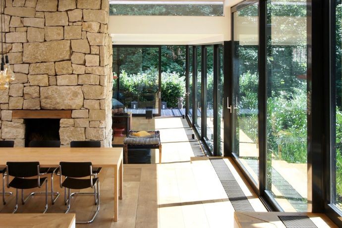 Pedra e vidro criam uma linguagem harmônica com a paisagem externa da casa (Foto: Immo Welt / Divulgação)