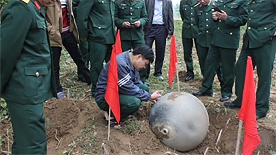 Autoridades escavam bolas de metal  (Foto: VIETNAM PEOPLE'S ARMY NEWSPAPER via Mashable)