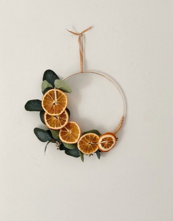 Esta guirlanda foi feita com um bastidor e pedaços de laranja, que dão um toque de cor e charme (Foto: Reprodução/Pinterest)