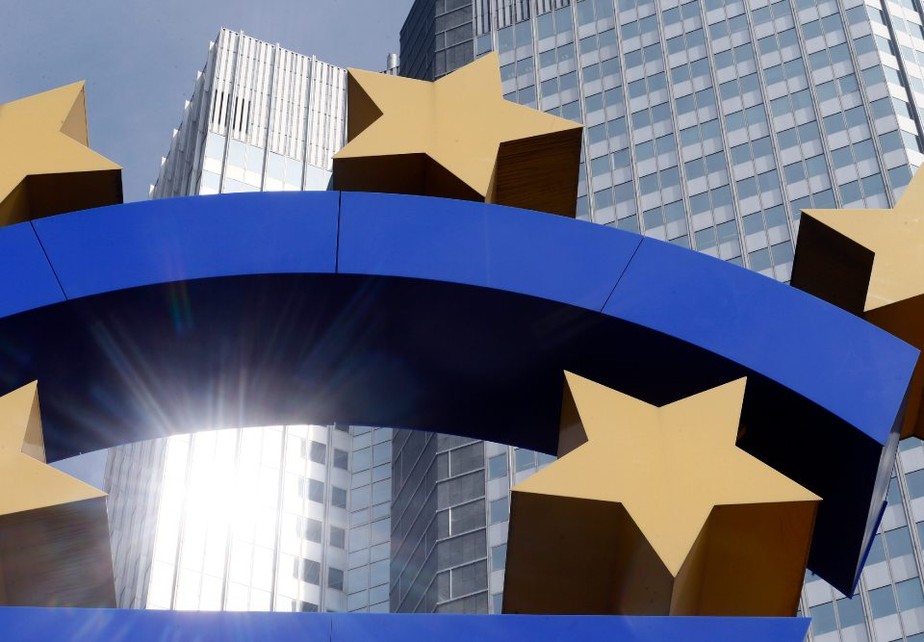 UE Europa Zona do Euro União Europeia Mario Draghi BCE Banco Central Europeu Sede Prédio - Pedestrians pass a euro sign sculpture outside the European Central Bank (ECB) headquarters in Frankfurt, Germany, on Thursday, April 4, 2013. European Central Bank