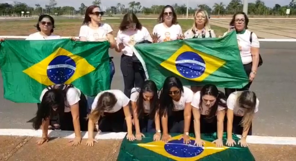 Grupo de 'bolsonarianas' oram com a bandeira do Brasil durante visita a Brasília — Foto: Reprodução/Redes sociais 