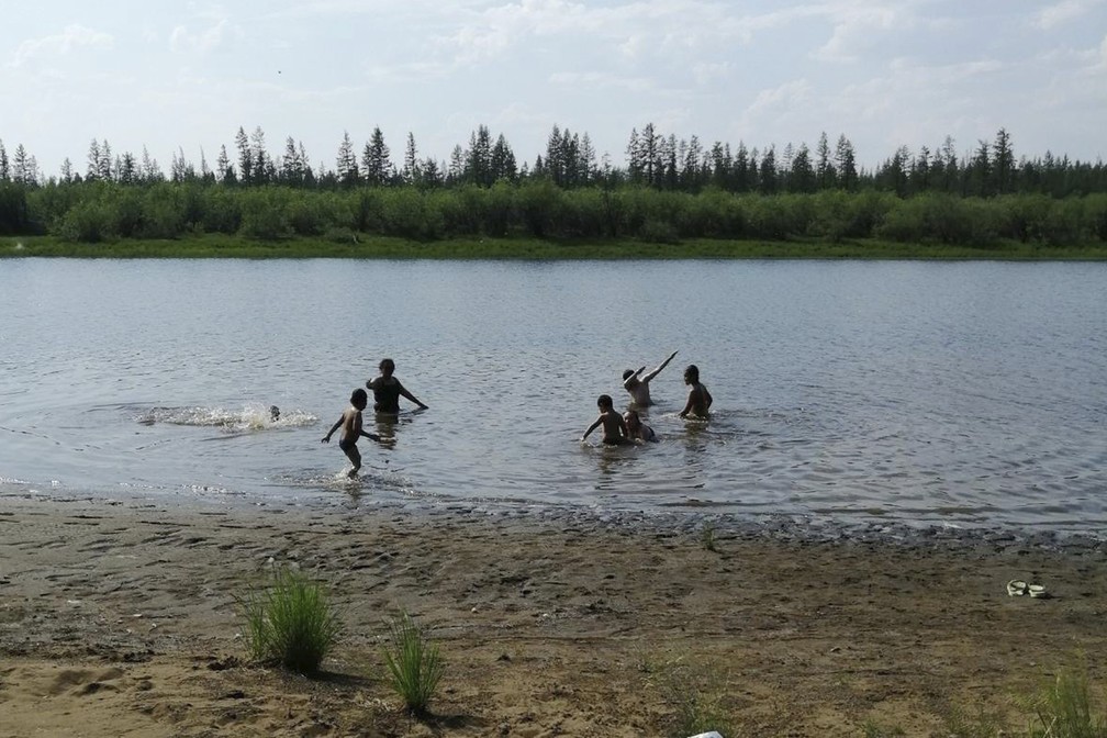 Crianças brincam em lago de Verkhoyansk, no norte da Rússia, no domingo (21) — Foto: Olga Burtseva via AP