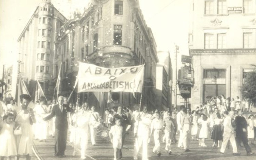 Cosme de Farias, à esquerda, segurando a faixa 'Abaixo o Analfabetismo' — Foto: Foto: Fundação Pedro Calmon [disponibilizada no Portal 2 de Julho]