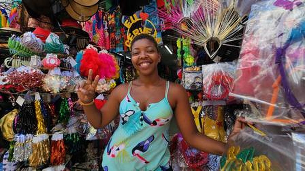 A vendedora Vanessa Santana mostra opções de arcos temáticos para o Carnaval: item sai por a partir de R$ 6 — Foto: Lucas Tavares/Agência O Globo