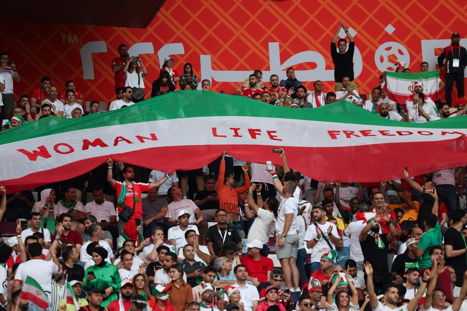 Torcedores no Estádio Internacional Khalifa, em Doha, levantam faixa em apoio aos protestos no Irã, antes de jogo entre as seleçoes iraniana e inglesa pela Copa do Mundo