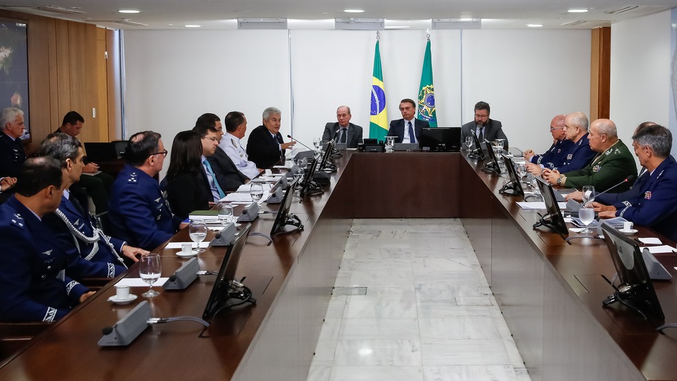 O presidente Jair Bolsonaro (ao fundo) durante reunião com ministros, no Palácio do Planalto, sobre o acordo entre Boeing e Embraer — Foto: Isac Nóbrega / PR
