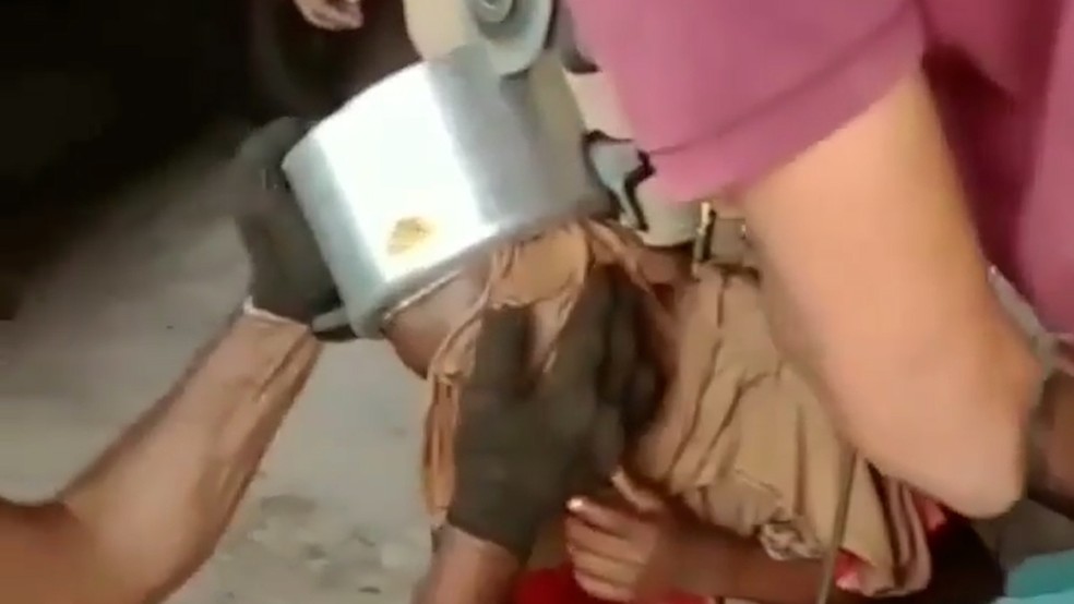 Moradores usaram uma espécie de lixadeira para cortar a panela na cabeça da criança, o que é considerado inseguro — Foto: Reprodução/Redes sociais