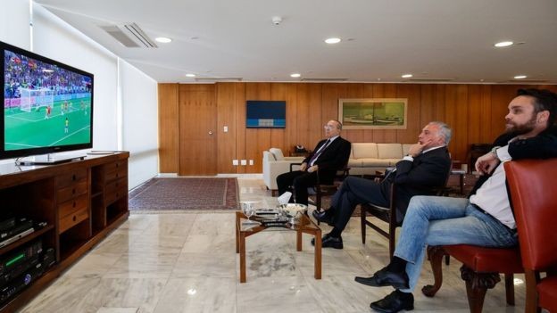 Temer e ministros assistindo ao jogo entre Brasil e Sérvia; presidente deve continuar sentindo desgastes das investigações contra si (Foto: Alan Santos/PR via BBC)